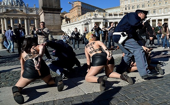 Femen activists protest in St.Peter's Square on November 14, 2014 at the Vatican. The protest is against the Pope's planned visit at EU parliament as an attack on secularism. AFP PHOTO / ALBERTO PIZZOLI        (Photo credit should read ALBERTO PIZZOLI/AFP/Getty Images)